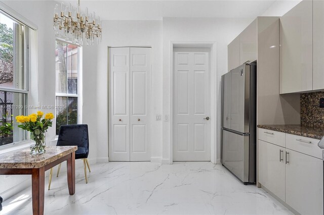 1382 Harbor Vw W, Hollywood, FL 33019 - kitchen featuring freestanding refrigerator, modern cabinets, light marble finish flooring, backsplash, and dark stone counters