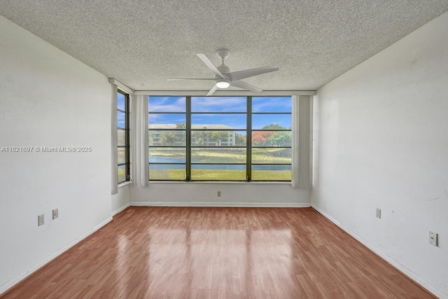 1520 Whitehall Dr Unit 103, Davie, FL 33324 - unfurnished room with a textured ceiling, a ceiling fan, wood finished floors, and a water view