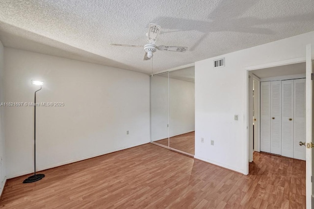 1520 Whitehall Dr Unit 103, Davie, FL 33324 - unfurnished bedroom featuring light wood-type flooring, a textured ceiling, and a ceiling fan