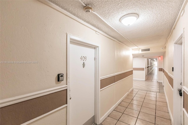 801 NW 47th Ave Unit 409W, Miami, FL 33126 - corridor featuring a textured ceiling and light tile patterned floors
