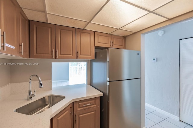 801 NW 47th Ave Unit 409W, Miami, FL 33126 - kitchen with freestanding refrigerator, a drop ceiling, light tile patterned floors, and light stone counters