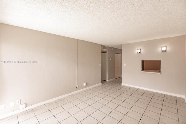 801 NW 47th Ave Unit 409W, Miami, FL 33126 - empty room featuring a textured ceiling and light tile patterned floors