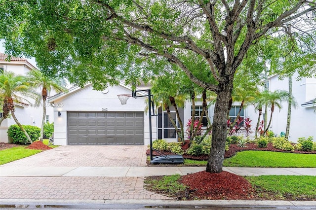 542 Penta Ct, Weston, FL 33327 - obstructed view of property featuring decorative driveway, an attached garage, and stucco siding