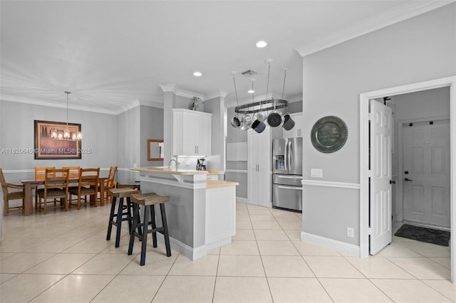 542 Penta Ct, Weston, FL 33327 - kitchen featuring stainless steel refrigerator with ice dispenser, ornamental molding, light countertops, light tile patterned flooring, and a breakfast bar area