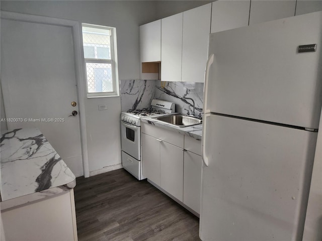 1239 Marseille Dr Unit 4, Miami Beach, FL 33141 - kitchen with white appliances, white cabinetry, dark wood finished floors, and tasteful backsplash