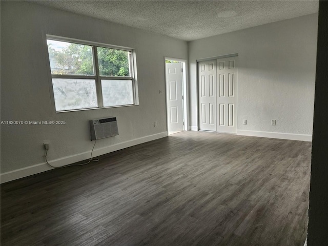 1239 Marseille Dr Unit 4, Miami Beach, FL 33141 - spare room with a textured ceiling, dark wood finished floors, and a wall mounted AC