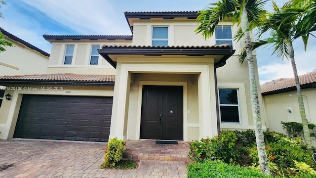 2190 SE 2nd St, Homestead, FL 33033 - doorway to property featuring stucco siding, a tiled roof, and a garage