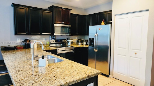 2190 SE 2nd St, Homestead, FL 33033 - kitchen with stainless steel appliances, a peninsula, light stone countertops, and light tile patterned floors