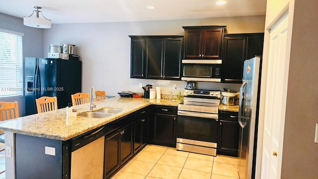 2190 SE 2nd St, Homestead, FL 33033 - kitchen featuring stainless steel appliances, a peninsula, light tile patterned flooring, light stone countertops, and recessed lighting