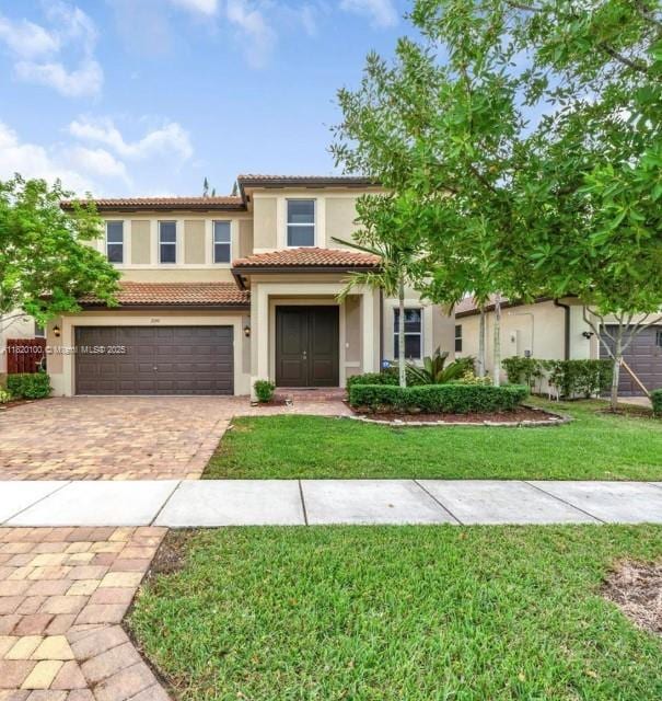 2190 SE 2nd St, Homestead, FL 33033 - view of front of house featuring stucco siding, decorative driveway, a garage, a tile roof, and a front lawn