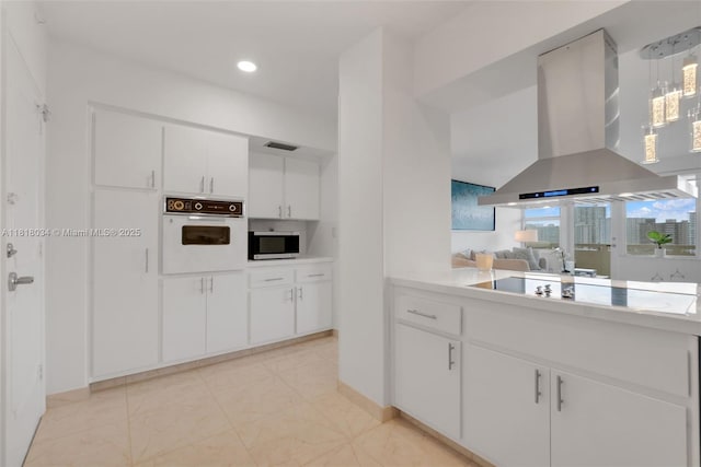 3200 NE 36th St Unit 1221, Fort Lauderdale, FL 33308 - kitchen with island exhaust hood, white oven, black electric cooktop, stainless steel microwave, and light countertops