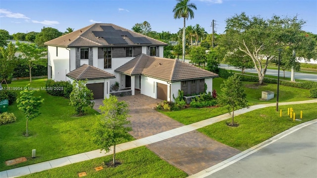 13005 Addilyn Ct, Davie, FL 33325 - view of front of house with a tile roof, solar panels, decorative driveway, and a front lawn