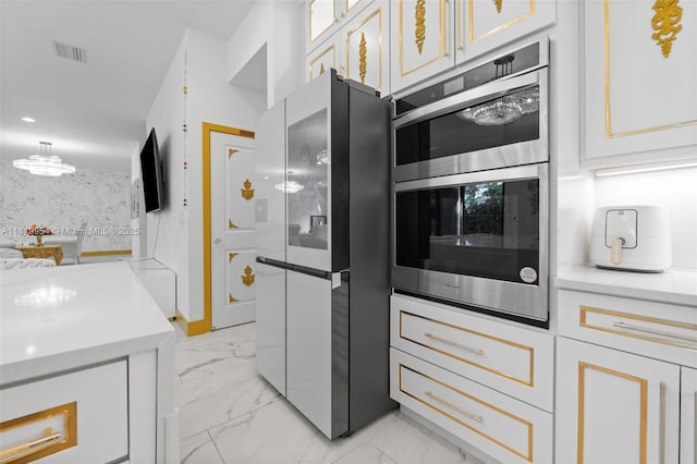 13005 Addilyn Ct, Davie, FL 33325 - kitchen with freestanding refrigerator, double oven, light marble finish floors, and white cabinets