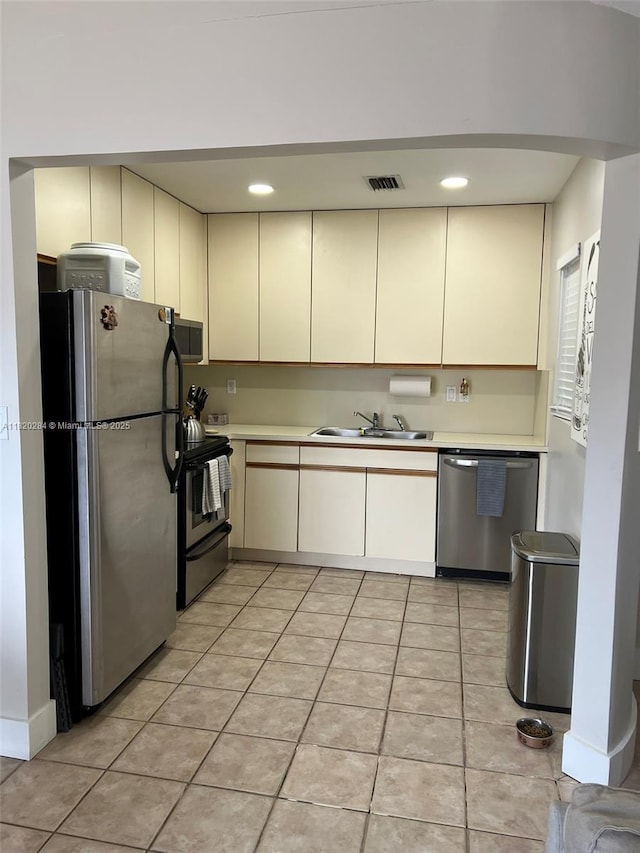 13766 SW 147th Cir Ln Unit 1-20, Miami, FL 33186 - kitchen featuring stainless steel appliances, cream cabinetry, light countertops, and light tile patterned floors