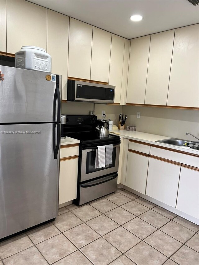13766 SW 147th Cir Ln Unit 1-20, Miami, FL 33186 - kitchen featuring appliances with stainless steel finishes, light countertops, light tile patterned floors, recessed lighting, and cream cabinets