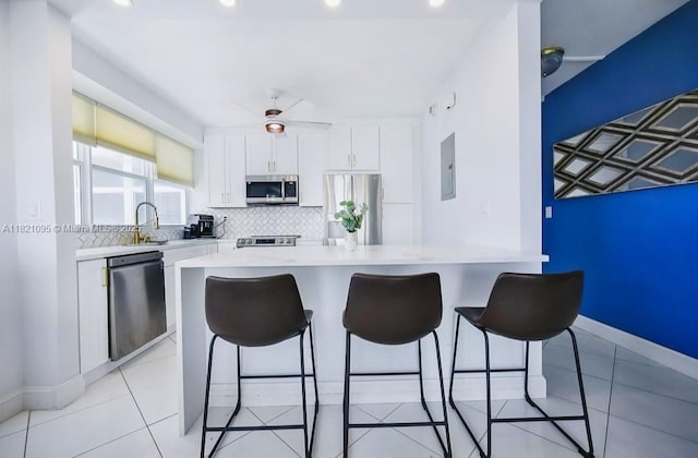 1920 S Ocean Dr Unit 901, Fort Lauderdale, FL 33316 - kitchen featuring stainless steel appliances, a breakfast bar, light countertops, white cabinetry, and tasteful backsplash