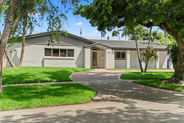 930 NE 182nd Ter, North Miami Beach, FL 33162 - single story home featuring curved driveway, stucco siding, and a front lawn