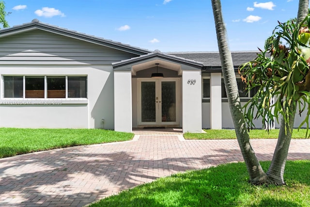 930 NE 182nd Ter, North Miami Beach, FL 33162 - view of front facade with french doors and stucco siding