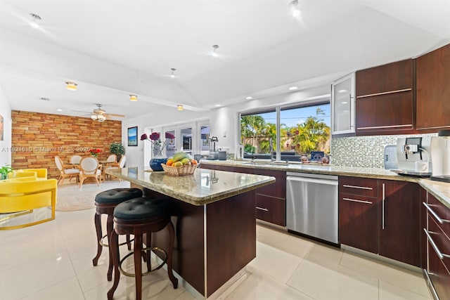 930 NE 182nd Ter, North Miami Beach, FL 33162 - kitchen featuring dishwasher, a breakfast bar area, a ceiling fan, light tile patterned floors, and a kitchen island