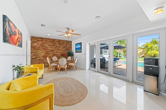 930 NE 182nd Ter, North Miami Beach, FL 33162 - sitting room featuring french doors, brick wall, a ceiling fan, and light tile patterned floors