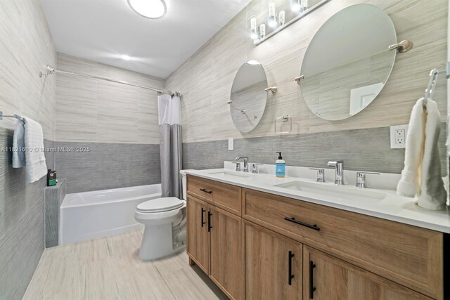 930 NE 182nd Ter, North Miami Beach, FL 33162 - full bath with double vanity, shower / tub combo, tile walls, and decorative backsplash