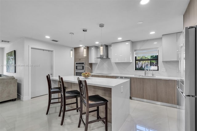 7100 Mcclellan St, Hollywood, FL 33024 - kitchen featuring modern cabinets, stainless steel appliances, wall chimney range hood, a breakfast bar, and white cabinetry