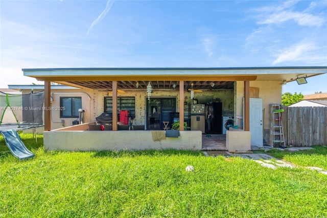 7100 Mcclellan St, Hollywood, FL 33024 - back of house with a trampoline, washer / clothes dryer, and stucco siding