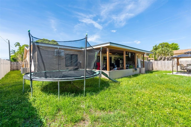 7100 Mcclellan St, Hollywood, FL 33024 - rear view of property with a trampoline, a patio area, a fenced backyard, and ceiling fan