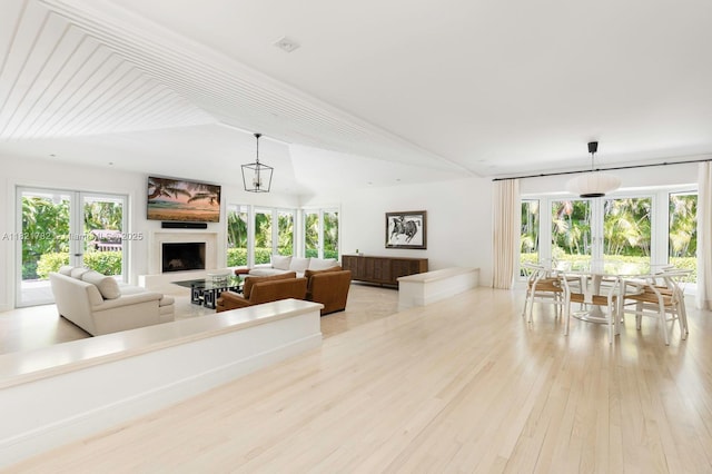 11100 Paradela St, Coral Gables, FL 33156 - living room with light wood-style floors, a fireplace with raised hearth, lofted ceiling, and french doors