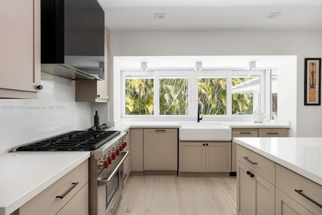 11100 Paradela St, Coral Gables, FL 33156 - kitchen with high end stainless steel range oven, extractor fan, light wood finished floors, and light countertops