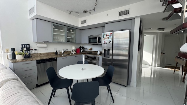 41 SE 5th St Unit 1716, Miami, FL 33131 - kitchen with appliances with stainless steel finishes, gray cabinets, dark countertops, and light tile patterned floors