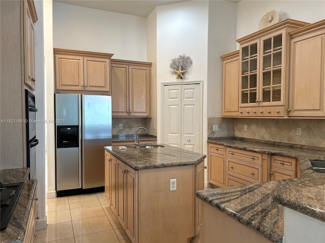 2640 Fairways Dr, Homestead, FL 33035 - kitchen with stainless steel refrigerator with ice dispenser, a kitchen island with sink, dark stone countertops, backsplash, and glass insert cabinets
