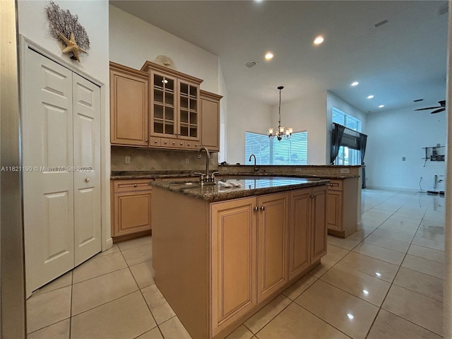 2640 Fairways Dr, Homestead, FL 33035 - kitchen with tasteful backsplash, a center island with sink, recessed lighting, light tile patterned flooring, and glass insert cabinets