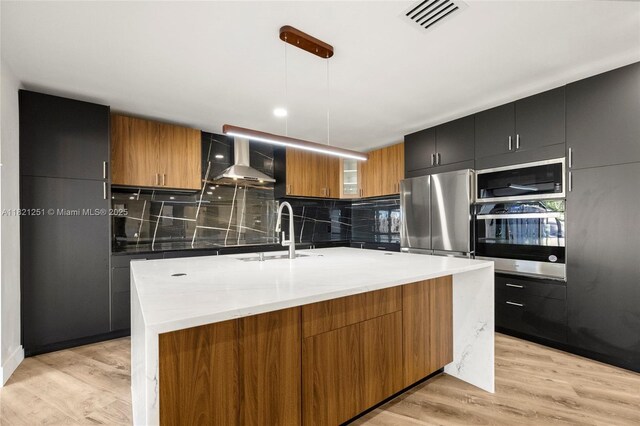 3910 NE 27th Ter, Lighthouse Point, FL 33064 - kitchen featuring appliances with stainless steel finishes, wall chimney range hood, and modern cabinets