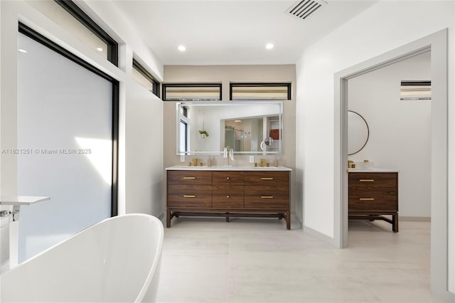 3910 NE 27th Ter, Lighthouse Point, FL 33064 - bathroom featuring double vanity, a freestanding bath, and recessed lighting