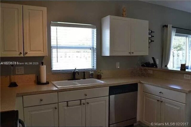 2402 NE 41st Pl, Homestead, FL 33033 - kitchen featuring dishwasher, white cabinetry, a peninsula, and light countertops