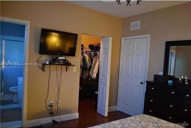 2402 NE 41st Pl, Homestead, FL 33033 - bedroom with a closet, a spacious closet, connected bathroom, and wood finished floors