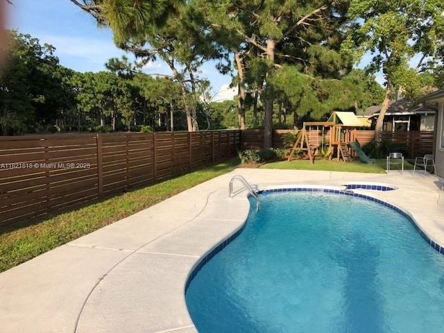 120 Hombre Cir Fl, Panama City Beach, FL 32407 - view of swimming pool with a fenced backyard, a playground, a patio, and view of scattered trees