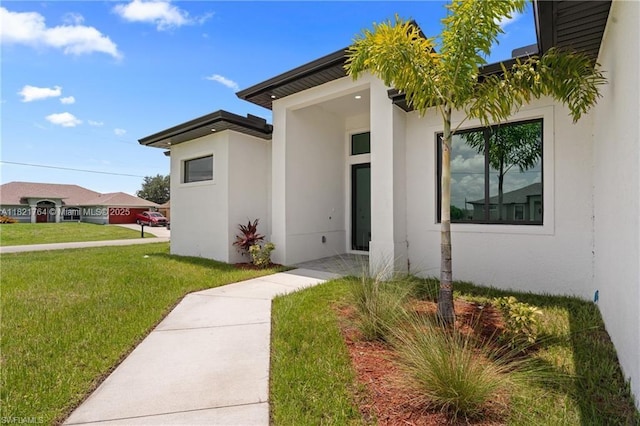 1003 Casino Ave, Lehigh Acres, FL 33971 - doorway to property with stucco siding and a lawn