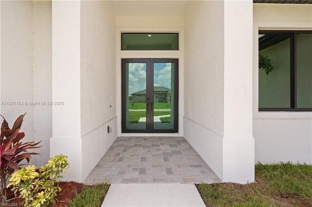 1003 Casino Ave, Lehigh Acres, FL 33971 - view of exterior entry featuring french doors and stucco siding