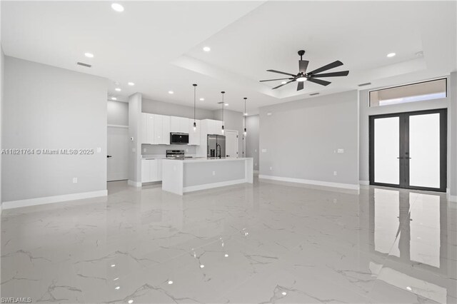 1003 Casino Ave, Lehigh Acres, FL 33971 - unfurnished living room featuring a raised ceiling, recessed lighting, french doors, light marble finish floors, and a ceiling fan