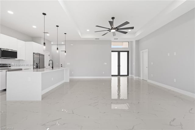 1003 Casino Ave, Lehigh Acres, FL 33971 - unfurnished living room with recessed lighting, a ceiling fan, a raised ceiling, light marble finish floors, and french doors