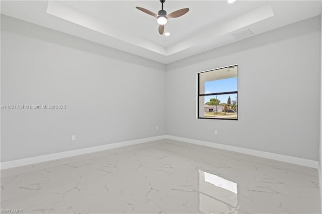 1003 Casino Ave, Lehigh Acres, FL 33971 - spare room with a tray ceiling, marble finish floors, ceiling fan, and recessed lighting