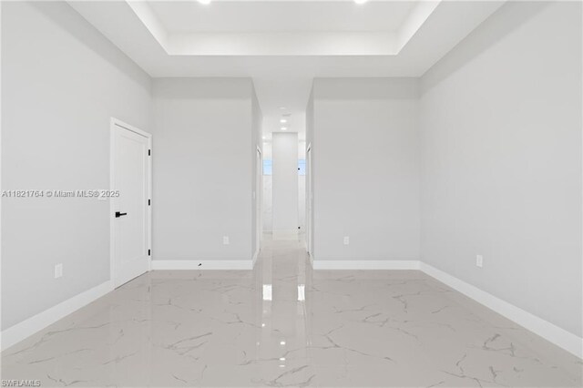 1003 Casino Ave, Lehigh Acres, FL 33971 - spare room with a tray ceiling, marble finish flooring, and recessed lighting