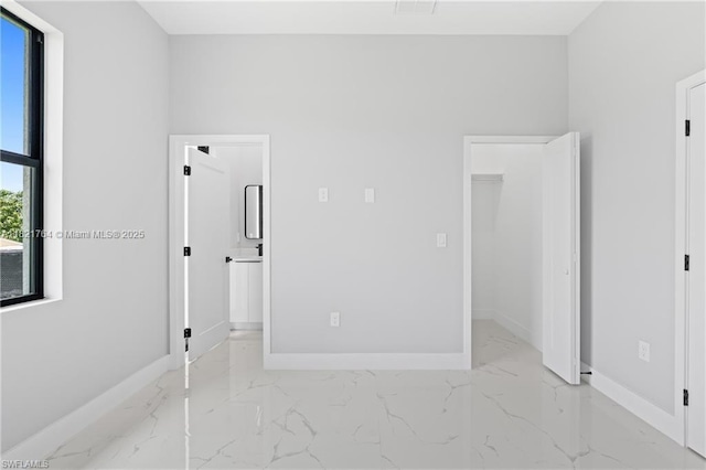 1003 Casino Ave, Lehigh Acres, FL 33971 - unfurnished bedroom featuring light marble finish flooring and connected bathroom
