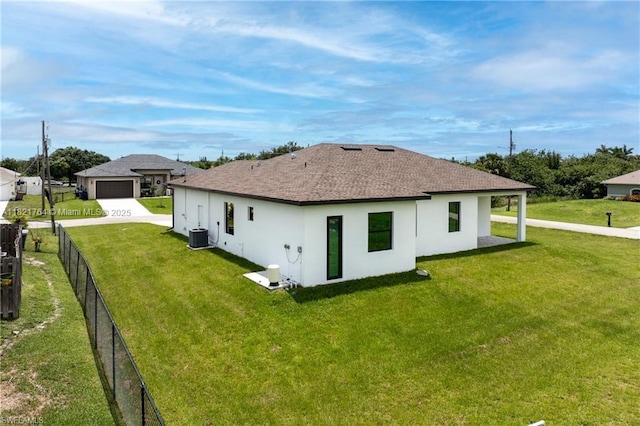 1003 Casino Ave, Lehigh Acres, FL 33971 - rear view of house with stucco siding, a shingled roof, driveway, and a detached garage