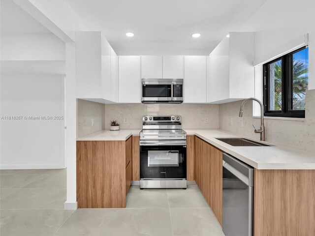 107 Central Ave, Delray Beach, FL 33483 - kitchen with stainless steel appliances, white cabinetry, light countertops, and recessed lighting