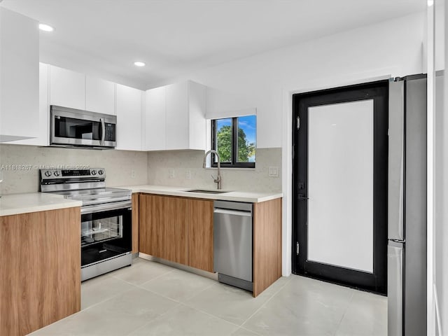 107 Central Ave, Delray Beach, FL 33483 - kitchen featuring appliances with stainless steel finishes, light countertops, white cabinetry, modern cabinets, and tasteful backsplash
