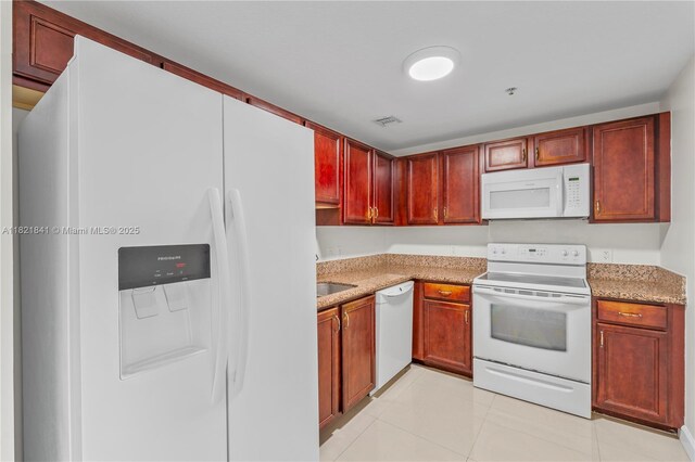 5271 SW 8th St Unit 213, Miami, FL 33134 - kitchen featuring white appliances, reddish brown cabinets, light tile patterned flooring, and light stone countertops