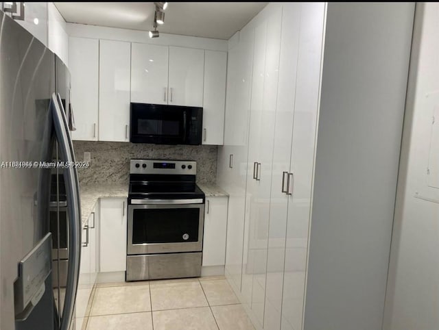 1965 S Ocean Dr Unit 5B, Hallandale Beach, FL 33009 - kitchen featuring refrigerator with ice dispenser, black microwave, stainless steel electric stove, white cabinetry, and light tile patterned floors